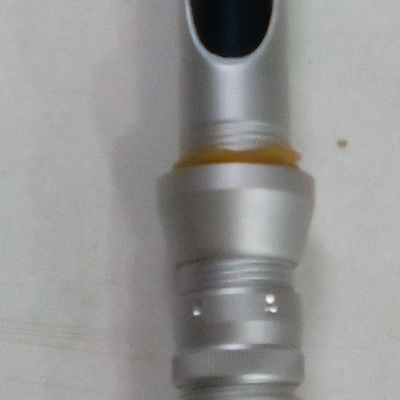 Punho e parte do cabo de uma cana de pesca com detalhes prateados e holográficos