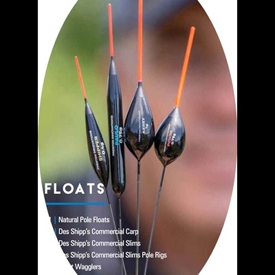 Conjunto de quatro boias de pesca pretas com ponteiras laranja, texto impresso, sendo seguradas pela mão em fundo desfocado.