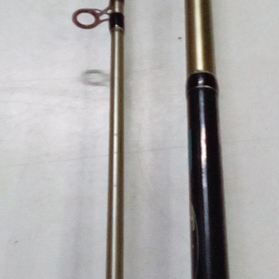 Vara de pesca segmentada dourada com cabo preto e padrão holográfico no punho