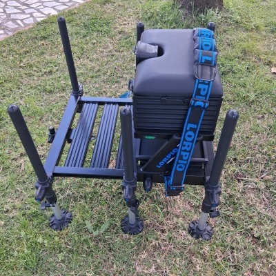 Cadeira de pesca preta com suporte azul e texto LORPIO sobre relva