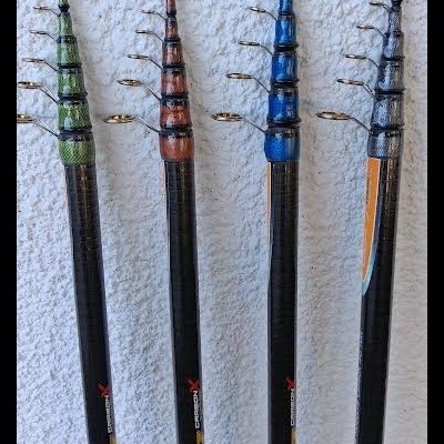Quatro varas de pesca telescópicas coloridas encostadas em parede