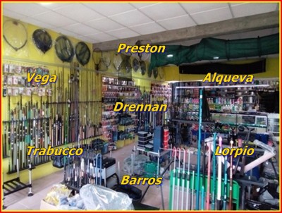 Loja de artigos de pesca com varas, acessórios e marcas visíveis na parede e prateleiras