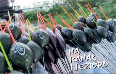 Bóias de pesca pretas e coloridas alinhadas ao ar livre perto de água