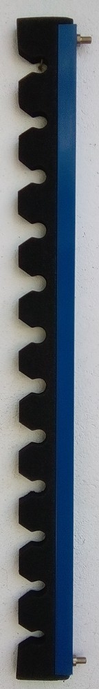 Suporte azul com peças pretas encaixadas numa parede branca.