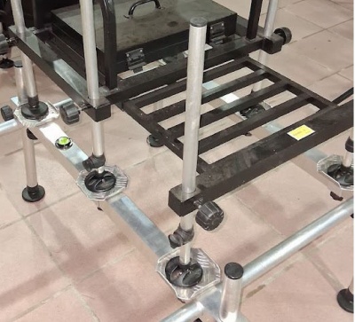 Estrutura metálica regulável com plataforma de barras pretas em chão de azulejos