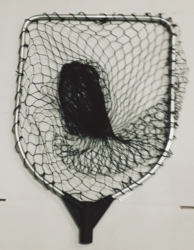 Rede de pesca quadrada com armação metálica e malha preta pendurada numa parede branca