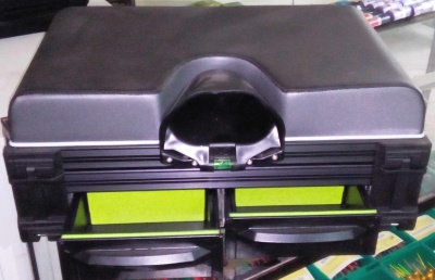 Caixa de ferramentas preta com gavetas verdes abertas