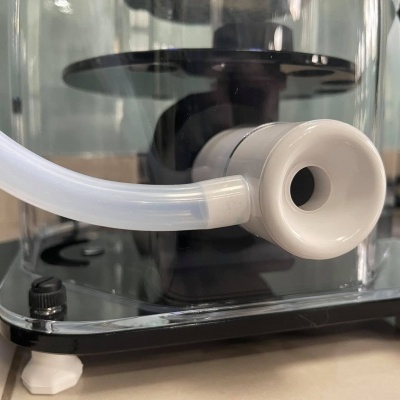 Máquina com tubo translúcido e bocal branco sobre base preta