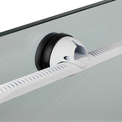 Raspador branco de silicone com ventosa preta numa superfície de vidro