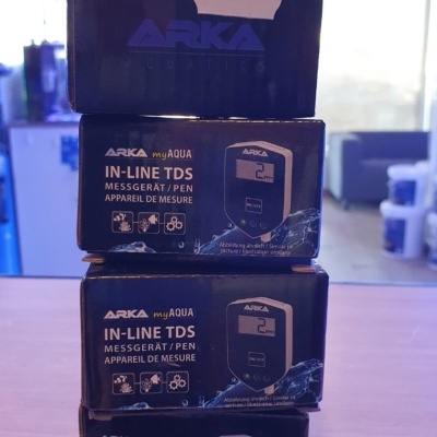 Caixas empilhadas do medidor ARKA myAQUA IN-LINE TDS com etiqueta de preço em ambiente interior