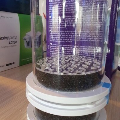 Reservatório transparente com filtro e texto multilíngue em mesa