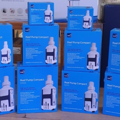 Caixas azuis do produto Reef Pump Compact empilhadas em ambiente interno