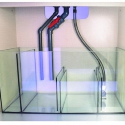 Aquário de vidro com divisórias e tubulação visível dentro de móvel