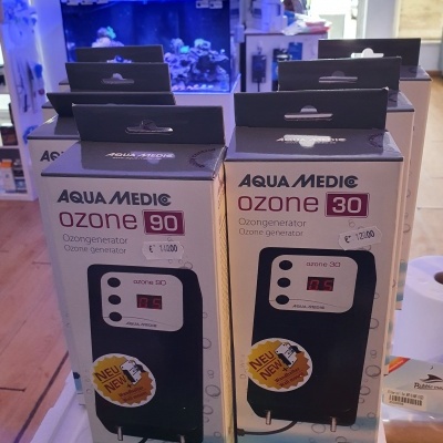 Caixas de geradores de ozono Aqua Medic em loja com aquário ao fundo