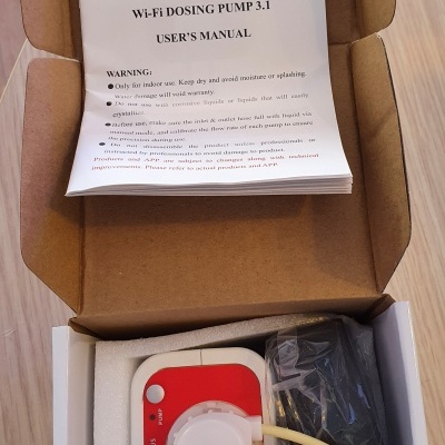 Caixa aberta com bomba de doseamento Jebao Wi-Fi Dosing Pump 3.1, manual do utilizador e componentes embalados