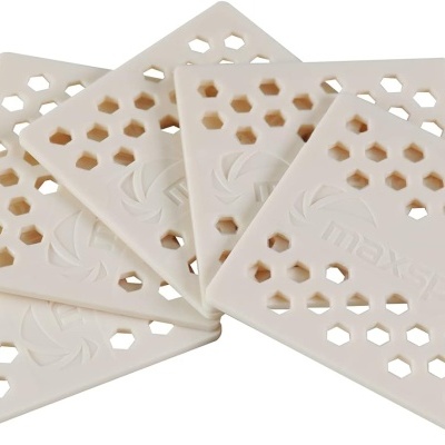 Placas quadradas brancas com padrão de hexágonos vazados e relevo de folhas