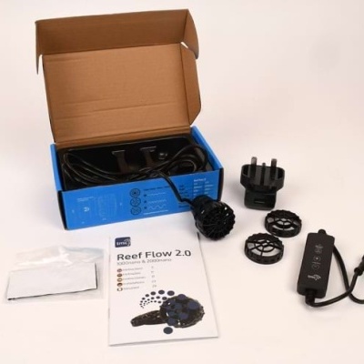 Kit de bomba submersível Reef Flow 2.0 com acessórios e manual, caixa azul aberta.