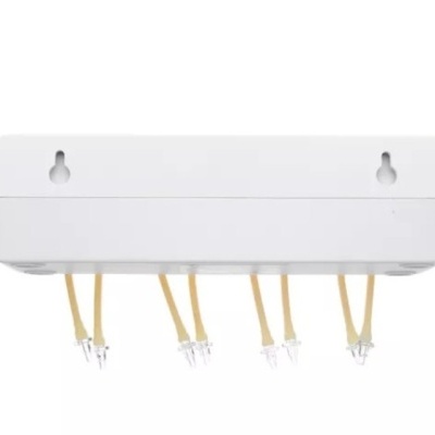 Suporte branco com ganchos metálicos dourados e fios amarelos.