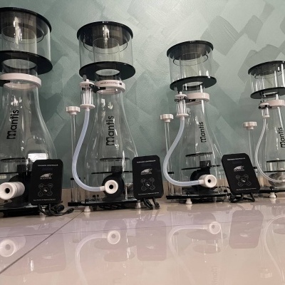 Quatro equipamentos transparentes com tubos em fila sobre chão branco