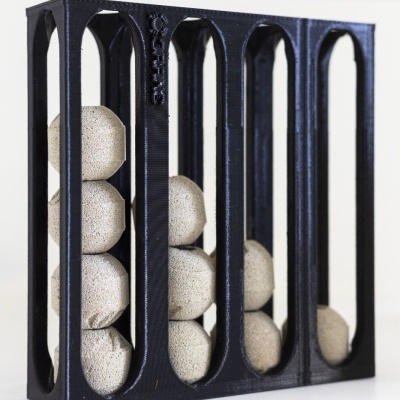 Estrutura preta com bolas cinzentas porosas organizadas em quatro colunas