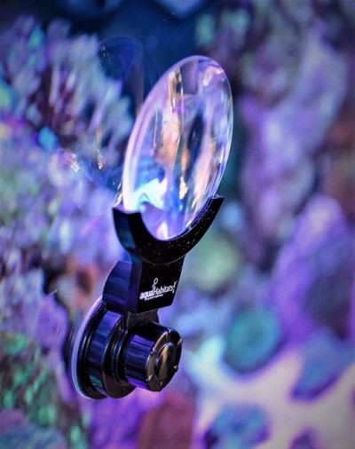 Lupa de aumento com suporte preto e ventosa fixada em vidro