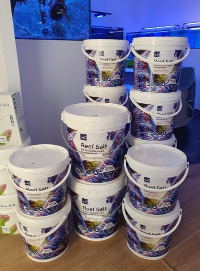 Embalagens de sal para recifes com etiquetas coloridas empilhadas em loja.