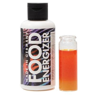 Frasco de suplemento alimentar ao lado de frasco com líquido colorido