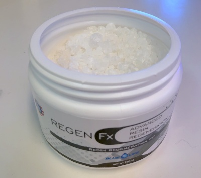 Frasco branco aberto com pequenas esferas transparentes e rótulo com texto REGEN Fx