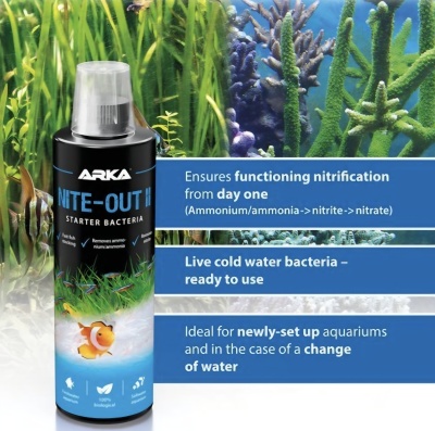 Frasco preto com tampa transparente e etiqueta azul com peixe-palhaço, plantas aquáticas ao fundo