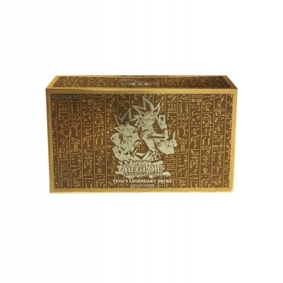 Caixa dourada com hieróglifos e personagem Yugi de Yu-Gi-Oh! e texto do produto