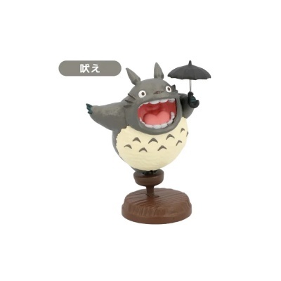 Boneco Totoro a segurar guarda-chuva sobre base castanha