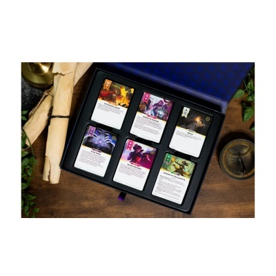 Cartas de jogo de fantasia numa caixa preta e azul sobre uma mesa de madeira