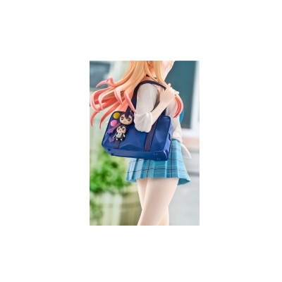 Figura anime feminina segurando bolsa azul com chaveiros de personagens