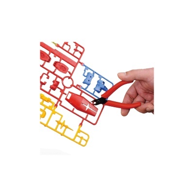 Mão segurando pinça vermelha corta plástico perto de moldura colorida de peças para modelo