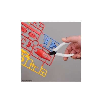 Mão a usar ferramenta para cortar peças coloridas de plástico para modelo