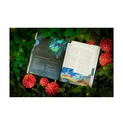 Livro aberto sobre folhas verdes com cogumelos vermelhos