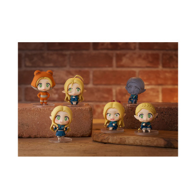 Figuras colecionáveis em miniatura com rostos expressivos sobre blocos de pedra e parede de tijolos