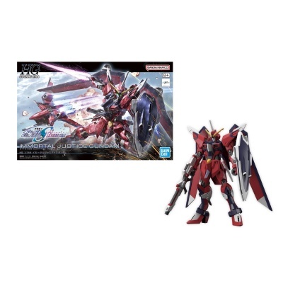 Modelo articulado de robô Gundam vermelho, azul e branco com escudo e arma, junto à caixa ilustrada com texto.