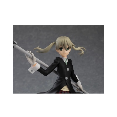 Figura anime feminina com cabelo loiro em rabos de cavalo vestindo casaco preto e gravata verde e branca segurando arma branca.