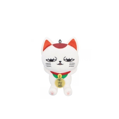 Pelúcia em forma de gato branco com detalhes laranja e medalha com texto asiático