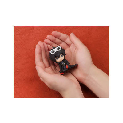 Figura de vinil colecionável com máscara branca e roupa preta nas mãos.