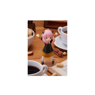 Figura de ação feminina com cabelo rosa e casaco preto com detalhes amarelos em mesa com café e nozes