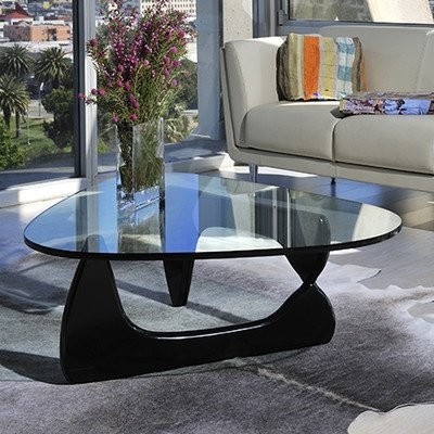 Mesa de centro de vidro com base preta curva na sala moderna