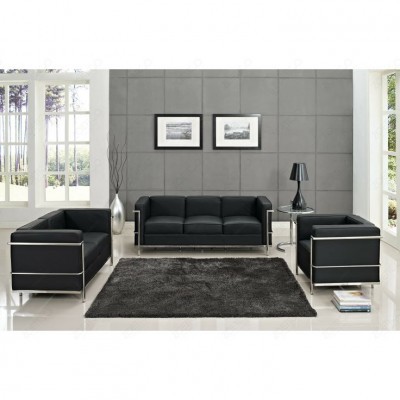Conjunto sala com sofás pretos em couro, tapete preto, mesa lateral e candeeiro, parede cinzenta com quadros e janelas grandes