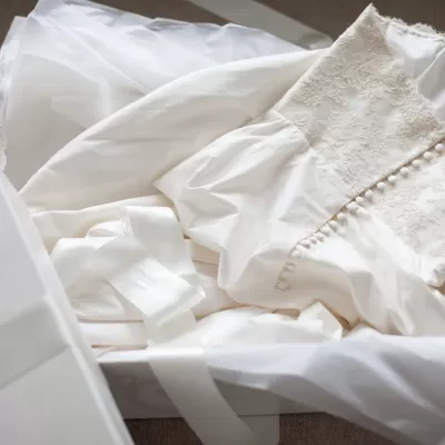 Tecido branco com renda floral e botões dentro de caixa branca