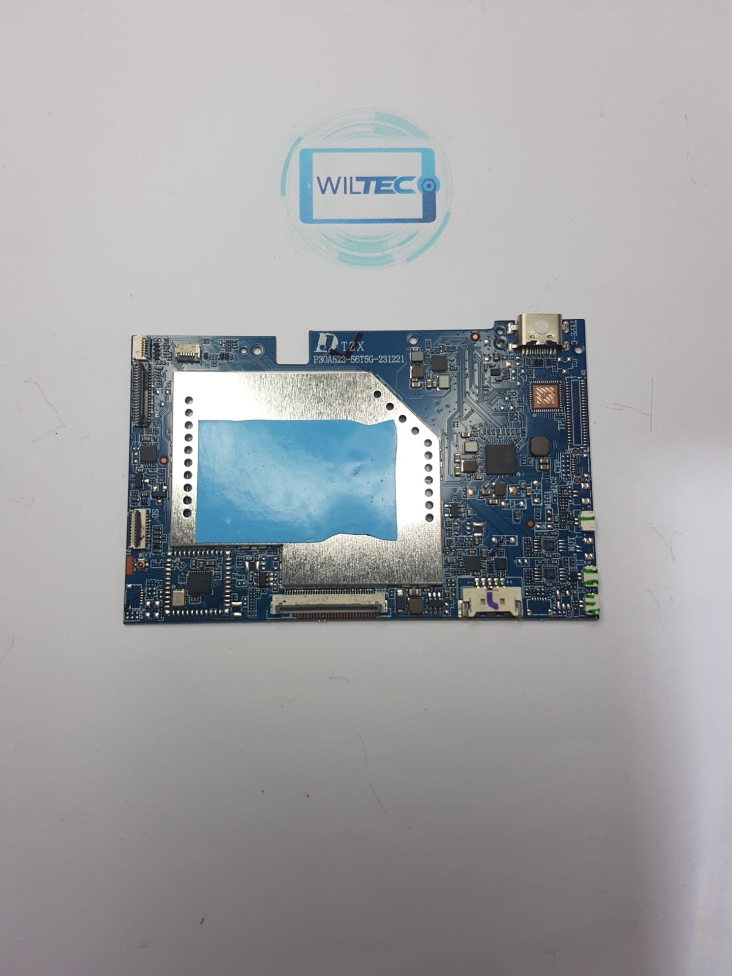 Motherboard Tablet SPC Gravity 5 SE 10.1 4GB/64GB Placa eletrónica azul com componentes e placa metálica prateada com área azul, sobre fundo branco com logo WILTEC.