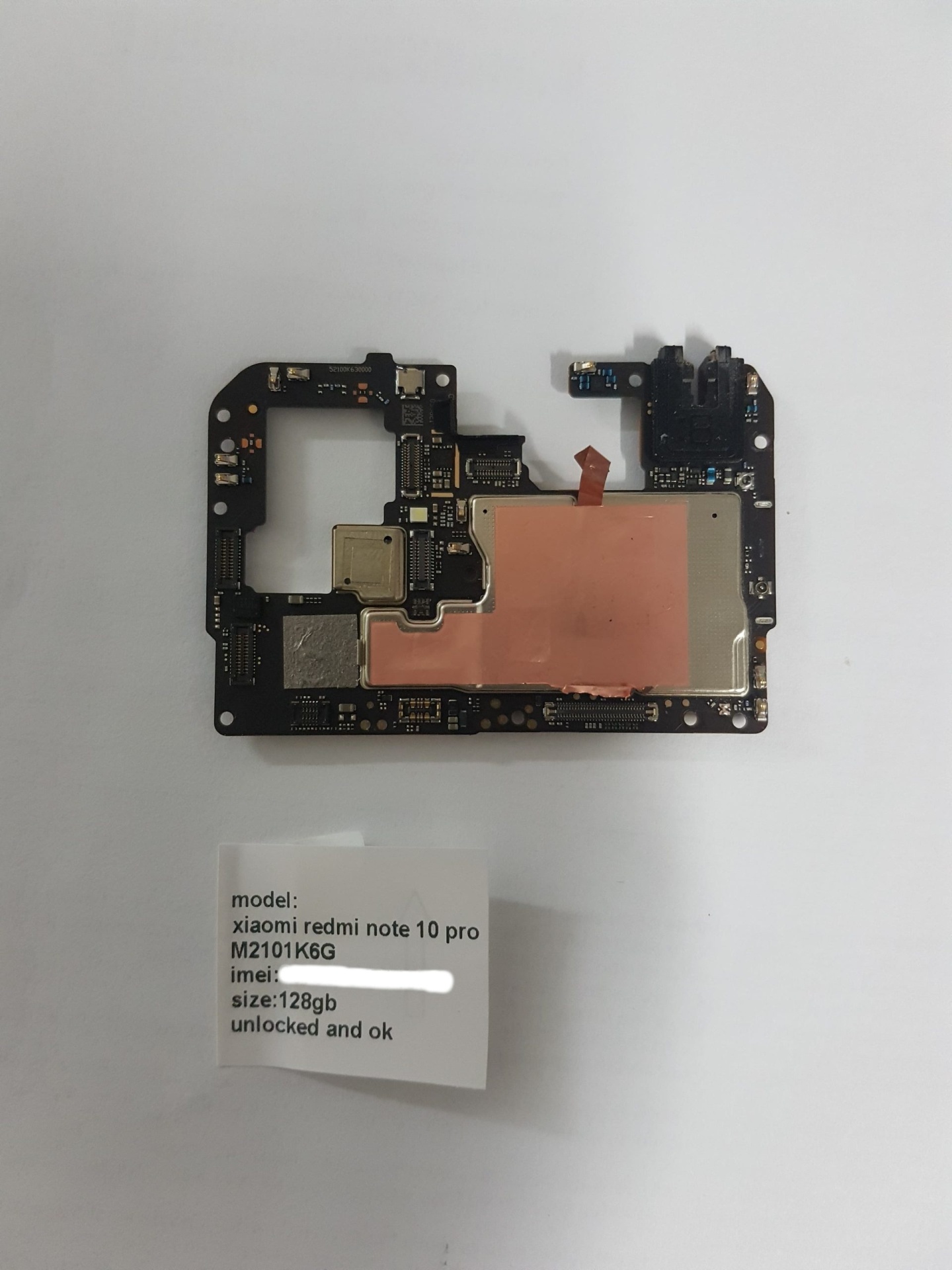 Motherboard Xiaomi Redmi Note 10 Pro (M2101K6G) – 128GB – Testada e Desbloqueada Placa mãe preta de Xiaomi Redmi Note 10 Pro com etiqueta informativa em fundo branco