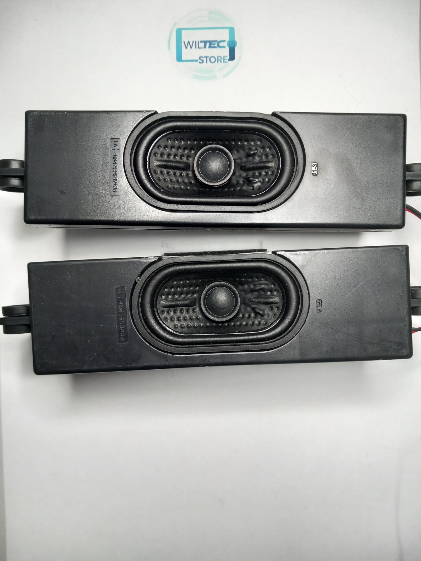 Speakers TV LG 65UT73006LA / 42-WFB418-X6IX1HX Dois altifalantes retangulares pretos sobre uma superfície branca com o logótipo WILTEC STORE.