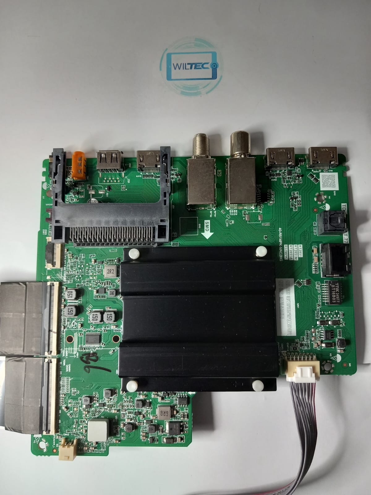 Mainboard TV TCL 55P61B / TD.RT2851AT.771 (T) Placa eletrónica verde com vários conectores e faixa de cabo cinzento sobre fundo branco com logótipo WILTEC