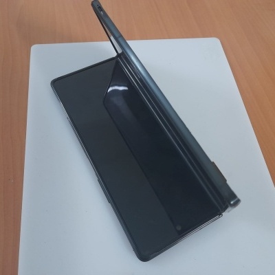 Smartphone preto com capa de proteção numa mesa